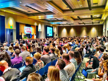 A large audience listening to a speaker