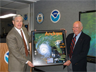 National Weather Service Director Jack Kelly presents civil engineer Herbert Saffir (on right) with a framed poster of Hurricane Andrew depicting the Saffir-Simpson scale for rating the strength of hurricanes